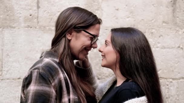 一对有爱心的年轻女同性恋夫妇站在外面的石墙前拥抱对方的画像 — 图库视频影像