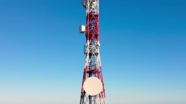 Primer plano aéreo de la torre de telecomunicaciones sobre fondo azul del cielo. Las antenas de torre de telecomunicaciones transmiten las señales de móviles celulares de 5g 4g. — Vídeos de Stock