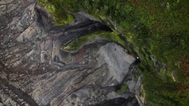 Manzaralı bir uçurum ve alçak akıntılı bir kıyı şeridi manzarasının hemen üstünde.