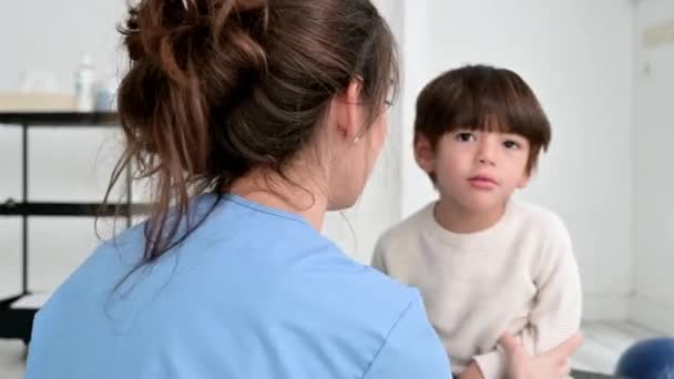 Fizjoterapeuta bawiący się dziecięcym porażeniem mózgowym w szpitalu, przybijający piątkę. — Wideo stockowe