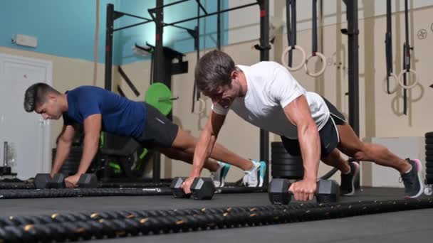 Twee sterke mannen doen push-ups in de sportschool. — Stockvideo