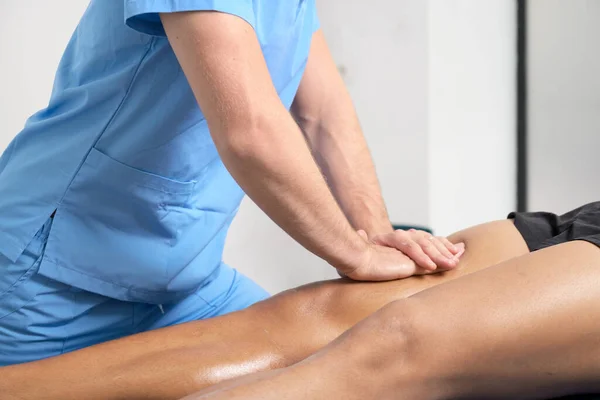 Primer plano del terapeuta que masajea la pierna de los hombres jóvenes —  Fotos de Stock