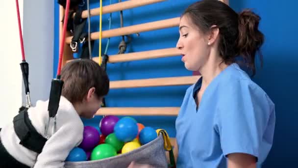 Sød knægt med cerebral parese laver muskuloskeletalterapi på hospitalet, mens du griner og har det sjovt . – Stock-video
