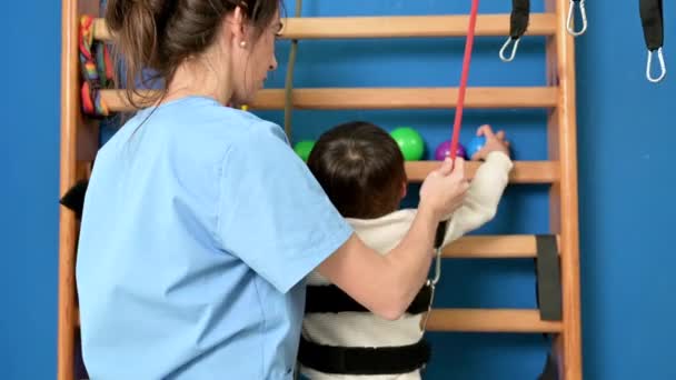 Engelli çocuk rehabilitasyon terapi hastanesinde oyun oynuyor, öğreniyor ve egzersiz yapıyor, engelli bir çocuğun yaşam tarzı. Mutlu engelli çocuk konsepti. — Stok video