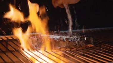 Şef ızgarayı tuzluyor. Yanan ızgarada taze et hazırlıyorum.. 