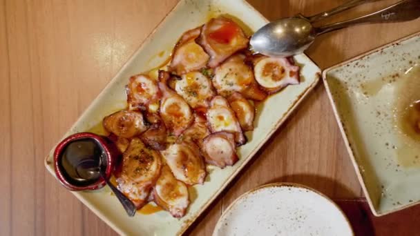 Безпосередньо над столом ресторану з тарілками гриль кальмарів і восьминогів з оливковою олією . — стокове відео