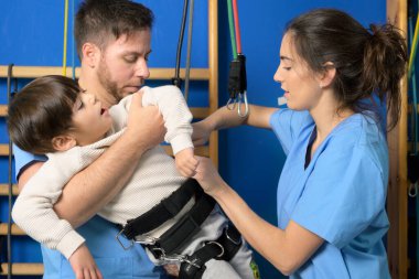 Fizyoterapistler hastanede rehabilitasyon için engelli bir çocuğu hazırlıyorlar..