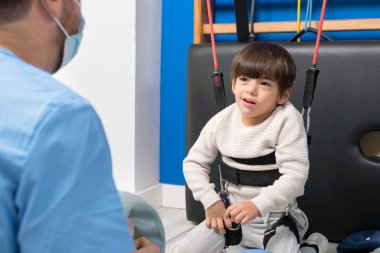 Serebral felçli tatlı bir çocuk hastanede kas dokusu terapisi yaparken gülüyor ve eğleniyor. .