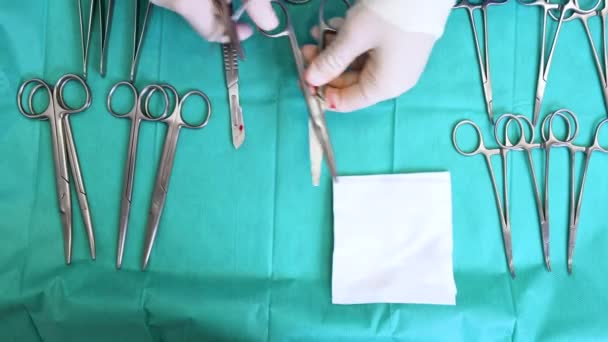 Flera kirurgiska instrument på blått bord ovan vy. Kirurg ta kirurgiska verktyg från bordet. — Stockvideo