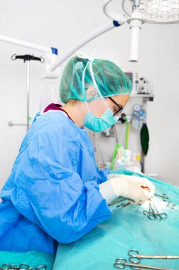 Ameliyathanede steril kıyafet giyen kadın cerrahın yakın plan portresi..