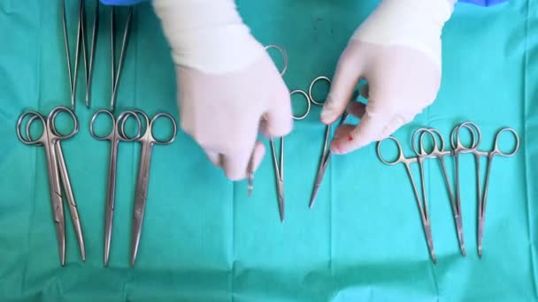 Instrumentos de cirugía múltiple en la mesa azul por encima de la vista. cirujano tomar herramientas quirúrgicas de la mesa. — Vídeos de Stock