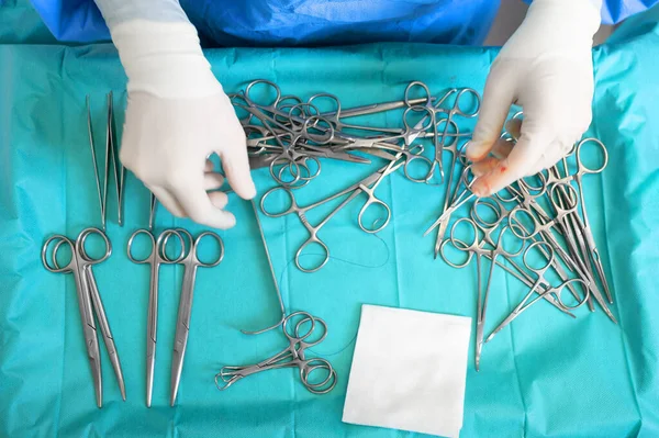 Múltiplos instrumentos de cirurgia na tabela azul acima vista. cirurgião tirar ferramentas cirúrgicas da mesa. — Fotografia de Stock