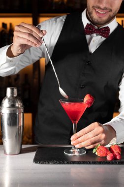 Genç barmen gece kulübünde kokteyl servisi yapıyor..