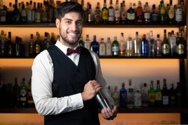 Barmen kokteyl barında kokteyl sallıyor.
