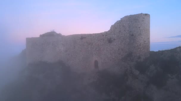 Воздушный панорамный вид на красивый средневековый замок, стоящий из тумана в туманное зимнее утро. — стоковое видео
