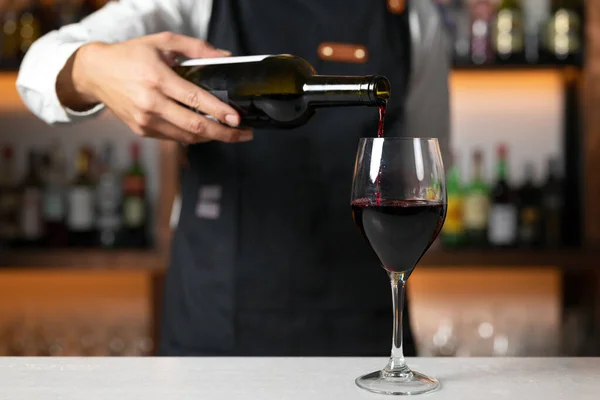 Μη αναγνωρίσιμος μπάρμαν που σερβίρει κόκκινο κρασί. Υψηλής ποιότητας φωτογραφία — Φωτογραφία Αρχείου