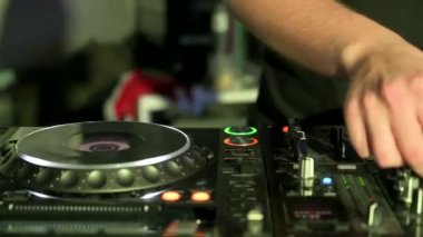 Mikser ve dijital pikaplarla çalan bir DJ 'in görüntüsü. Gece kulübünde elektronik müzik Jokeyi tarafından çalınan kablolu, düğmeli ve kaydıraklı CDJ turntable 'lar.