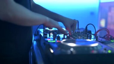 Mikser ve dijital pikaplarla çalan bir DJ 'in görüntüsü. Gece kulübünde elektronik müzik Jokeyi tarafından çalınan kablolu, düğmeli ve kaydıraklı CDJ turntable 'lar.