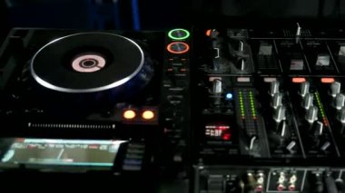 Mikser ve dijital pikaplarla çalan bir DJ 'in görüntüsü. Gece kulübünde elektronik müzik Jokeyi tarafından çalınan kablolu, düğmeli ve kaydıraklı CDJ turntable 'lar.