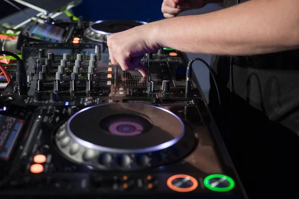Close-up van Dj Mixer Controller Desk in Night Club Disco Party. DJ handen aanraken knoppen en schuifregelaars spelen elektronische muziek . — Stockfoto