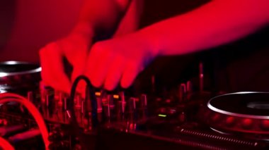Dj mixing at party festival with light and smoke in background - Summer nightlife view of disco club inside. Focus on hand