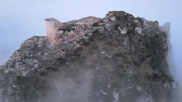 Vista panorâmica aérea de um belo castelo medieval que se destaca do nevoeiro em uma manhã enevoada de inverno. — Vídeo de Stock