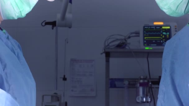 Strzał w górę kobiet chirurgów w mundurze medycznym za pomocą profesjonalnych narzędzi, stojąc w jasnym świetle w sali operacyjnej — Wideo stockowe