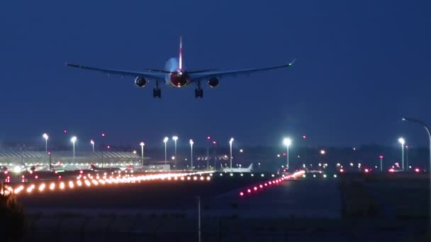 Pesawat mendarat di landasan pacu bandara di malam hari — Stok Video
