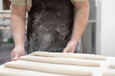 Fırında çalışan fırıncı tepsileri taze somunla hazırlıyor.. 