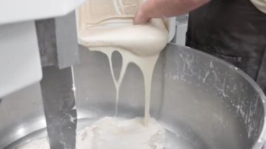 Baker ekmek fabrikasındaki hamur karıştırıcısına ekşi ekmek döker..