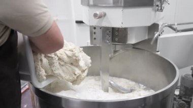 Baker ekmek fabrikasındaki hamur karıştırıcısına ekşi ekmek döker..