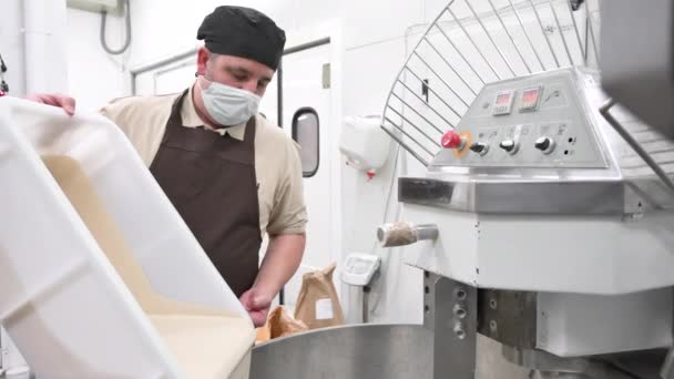 Пекарь наливает тесто в тестомешалку на хлебозаводе. — стоковое видео