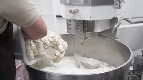 베이커가 빵 공장의 반죽 혼합물에 소스 반죽을 붓다. — 비디오