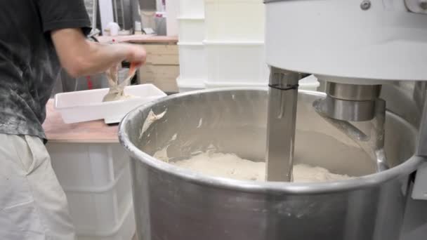 Пекарь вынимает тесто из смесительной машины в промышленной пекарне — стоковое видео