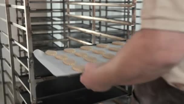 빵집에 빵 반죽을 담은 쟁반을 들고 있는 베이커. — 비디오