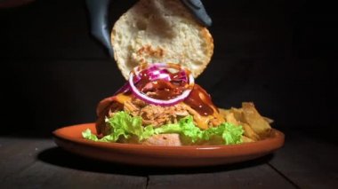 Tanınmayan bir şefin, ahşap bir tabakta patates kızartmasıyla servis edilen lezzetli domuz burgerini bitirmesine az kaldı.
