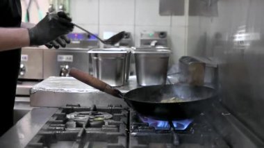 Şef Cookin Wokg 'un Mutfakta Yavaş Çekimi. Restoran yangını, yakın yemek, ticari mutfakta sebze kızartma.. 