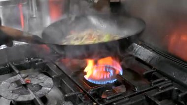 Şefin tavada sebzeli udon eriştesi pişirmesine yakın durun.