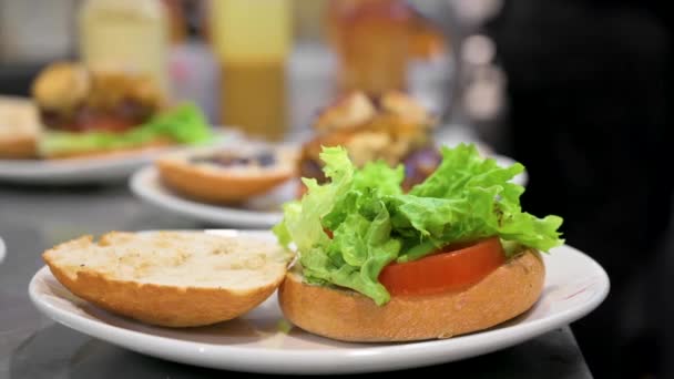Chef hamburger di cottura, mettendo carne tritare sulla lattuga primo piano, fare panino, concetto di fast food, ricetta di preparare hamburger fatti in casa con verdure. — Video Stock