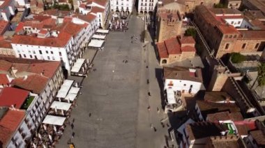 Güneşli bir günde İspanya 'nın Caceres kentindeki turistlerin yürüdüğü ana meydanın hava manzarası. Kasaba salonu manzarası. 