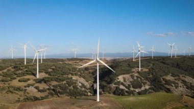 Güneşli bir günde enerji üreten yel değirmenlerinin havadan görünüşü. Rüzgar güç türbinleri sürdürülebilir kalkınma için temiz yenilenebilir enerji üretiyor