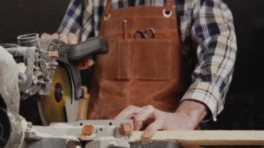 Marangoz elektrikli testere kullanıyor, odun kesiyor..