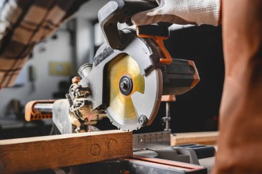 Marangoz elektrikli testere kullanıyor, odun kesiyor..
