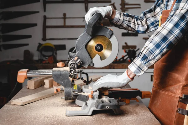 Carpintero usando una sierra circular eléctrica, cortando pieza de madera. — Foto de Stock
