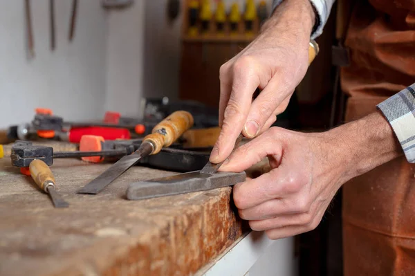 Carpenter sharpening a chisel. woodworking process with hand tools in a carpentry workshop. wood carving concept — Stock Photo, Image