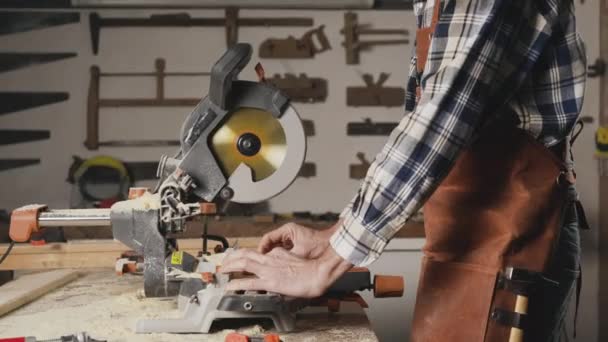 Tischler mit einer elektrischen Kreissäge, die ein Stück Holz schneidet. — Stockvideo