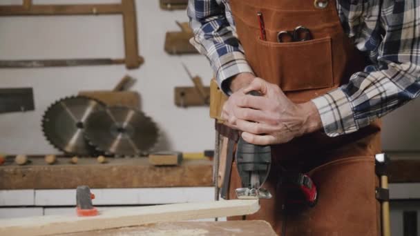 Carpenter sta segando una tavola di legno con seghettatrice elettrica in falegnameria. Workwood concetto fai da te — Video Stock