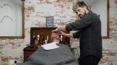 Keskin bir ustura ile tıraş sakallı erkek berber