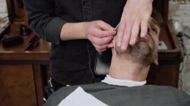 Keskin bir ustura ile tıraş sakallı erkek berber