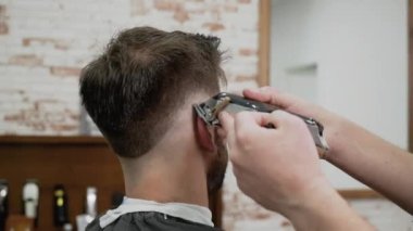 Adam Kuaför kesim saç kesme makinesi kuaför dükkanında erkek istemcinin. Saç şekillendirme işlemi. Ağır çekim yakın çekim